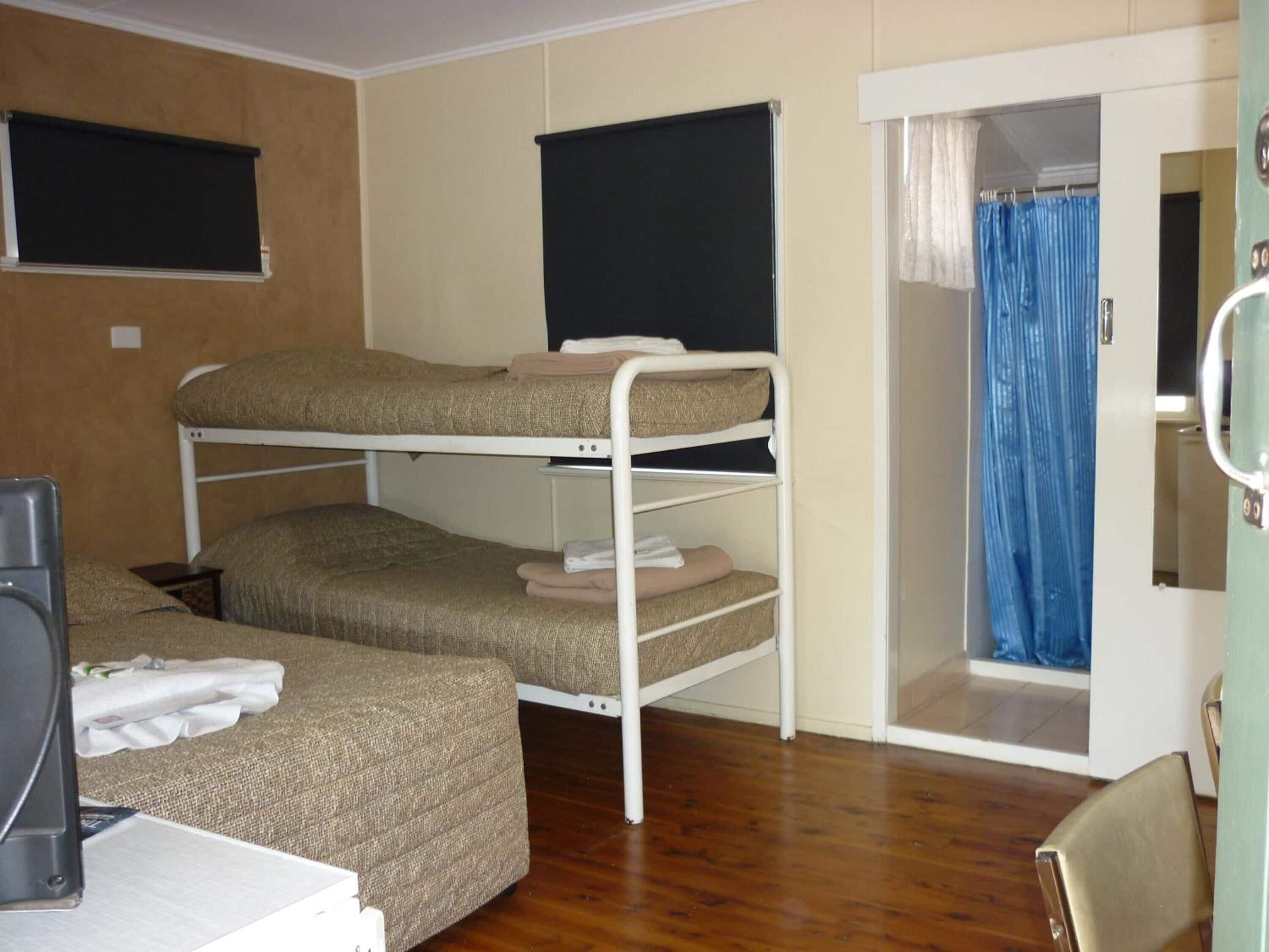 Habitación con literas, escritorio y zona de ducha.