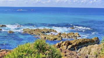 A coastal landscape with rocky terrain and clear blue waters.