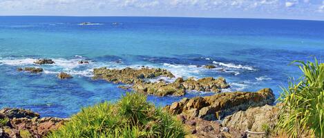 A coastal landscape with rocky terrain and clear blue waters.