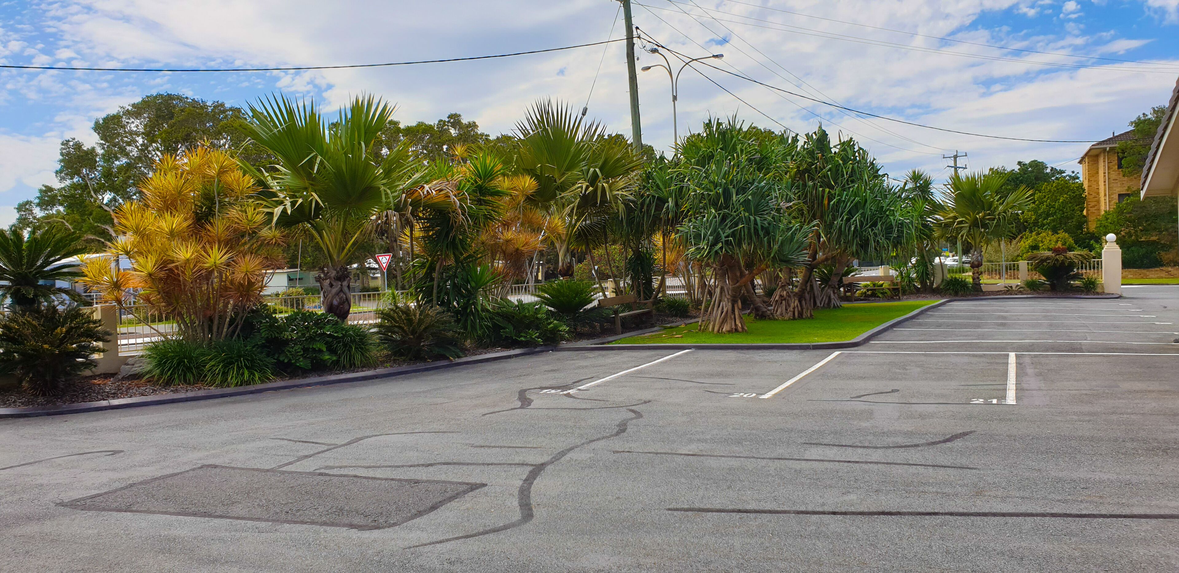 A parking lot with marked parking spaces and a triangular warning sign.