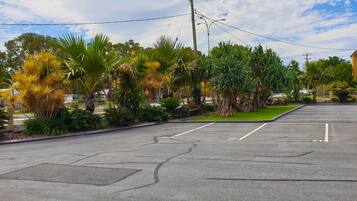 A parking lot with marked parking spaces and a triangular warning sign.