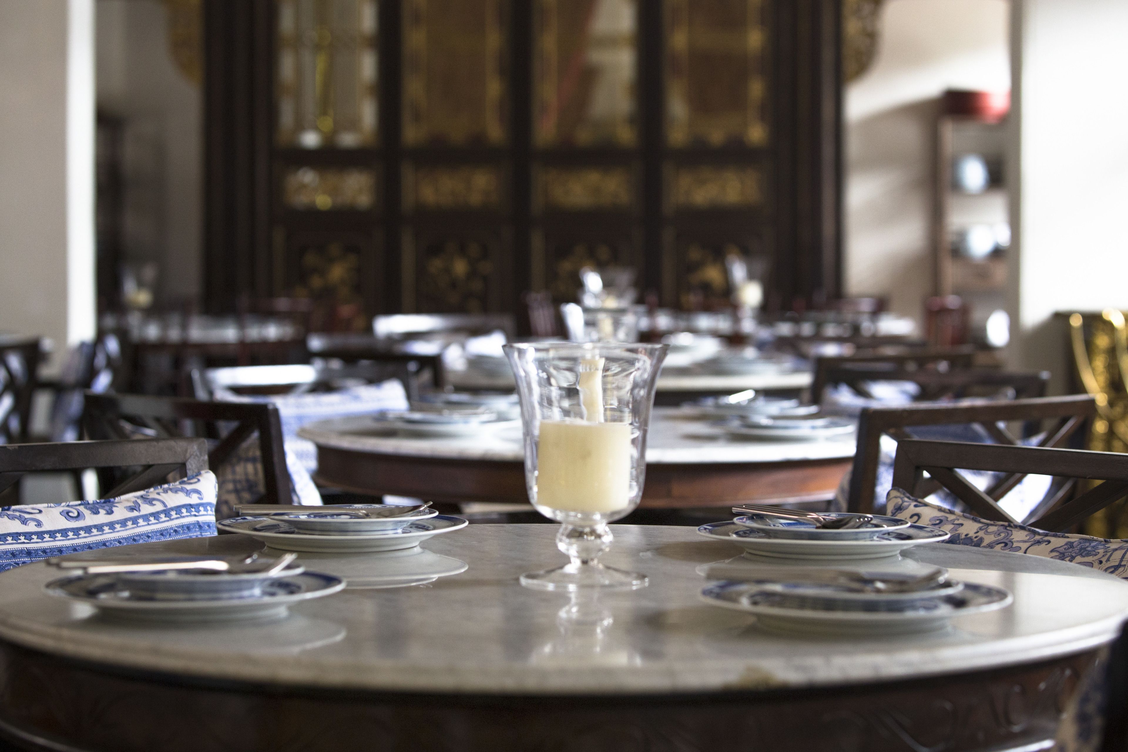 A dining table with plates, a glass of milk, and chairs.