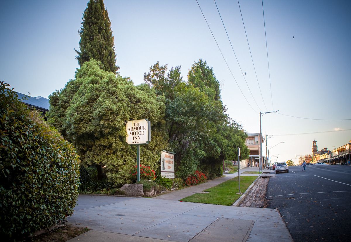 A street view with a sign for The Armour Motor Inn.
