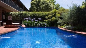 A swimming pool with a brick edge and a sign indicating a dry area.