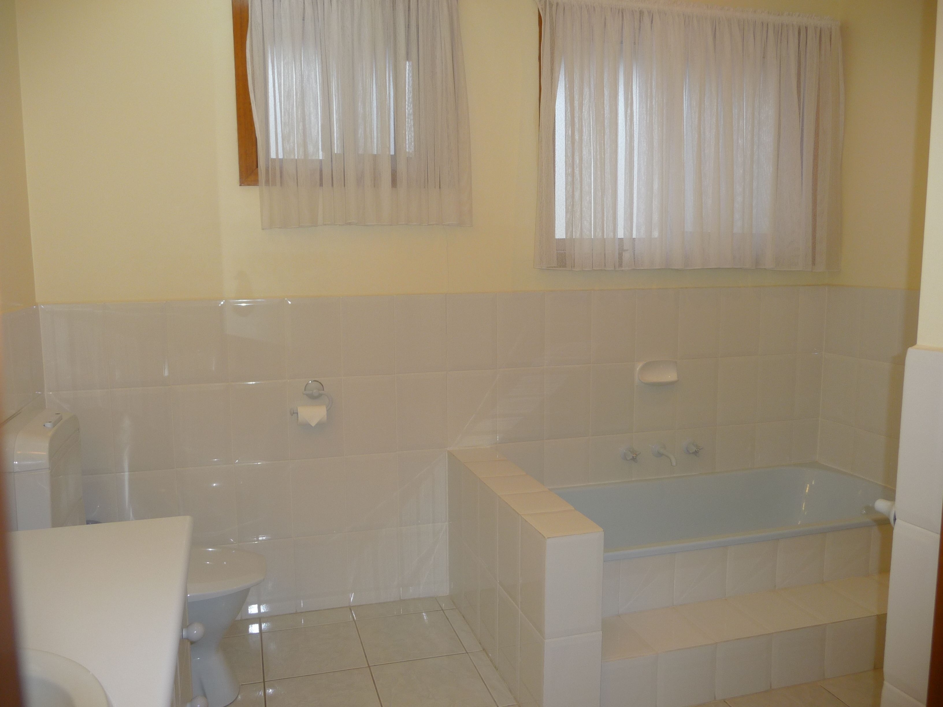 Ein Badezimmer mit Badewanne, Toilette und Handtuchhalter.
