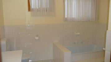 Ein Badezimmer mit Badewanne, Toilette und Handtuchhalter.