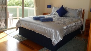 A bedroom with a bed, a view of the outdoors, and a painting on the wall. - Angela's Beach Stays (Apollo Bay)