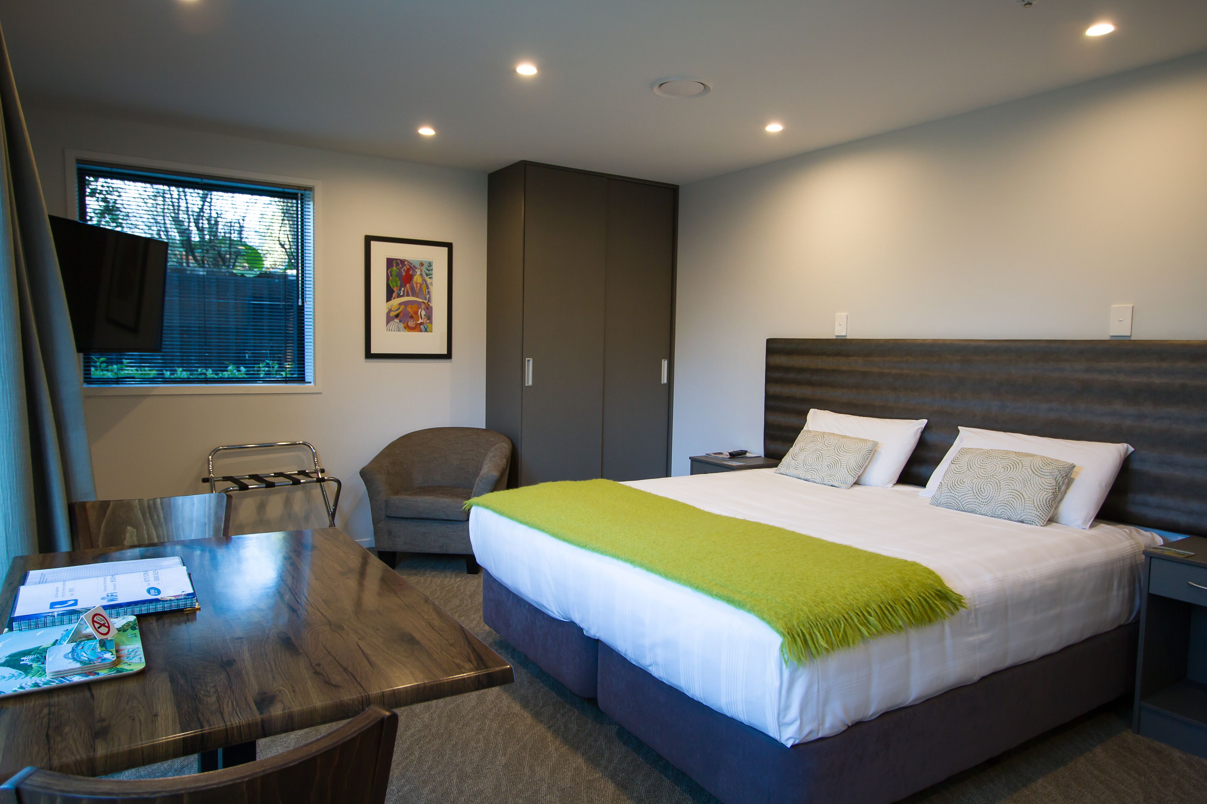 Een moderne hotelkamer met een groot bed, een bureau en een stoel.
