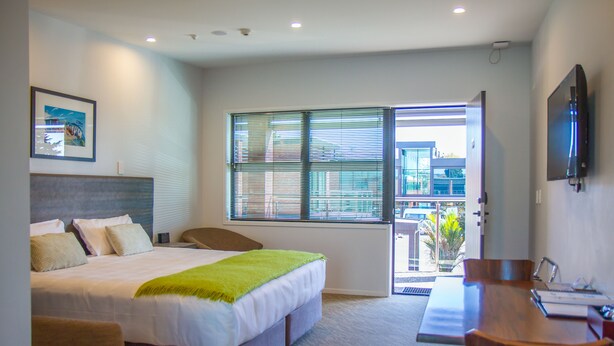 A hotel room with a bed, a desk, and a TV. - 850 Cameron Motel (Tauranga)