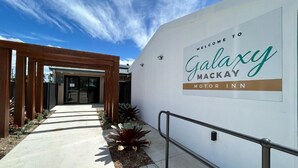 A welcome sign for Galaxy Mackay Motor Inn with a clear pathway leading to the entrance. - Galaxy Mackay Motor Inn (West Mackay)