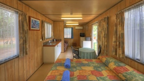 A compact room with a bed, a small kitchenette, a dining area, and a TV. - Batchelor Holiday Park (Batchelor)