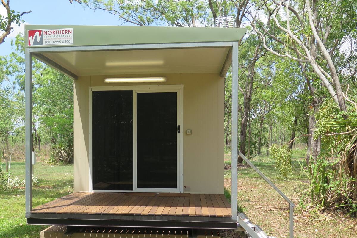 A small, single-story structure with a covered porch and a sliding glass door.