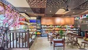 Un magasin moderne proposant une grande variété de produits, avec des étagères bien garnies et un espace détente équipé de tables et de chaises.