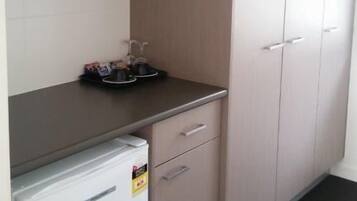 A kitchenette with a refrigerator, a sink, and a countertop.