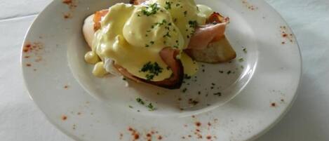 A plate with a dish that includes poached eggs, smoked salmon, and a garnish of herbs.