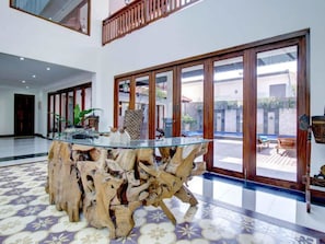 Enjoy a bright and airy space with a central table and large sliding glass doors leading to an outdoor area.
