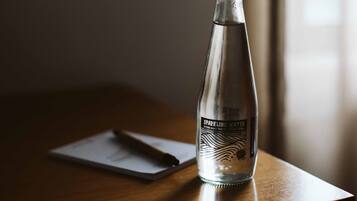 Una bottiglia di vetro trasparente con l'etichetta “Sparkling Water” su un tavolo di legno.