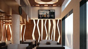 A modern lobby with a central seating area, a clock, and a movie poster on the wall. - My Ngoc Hotel Catba (Hai Phong)