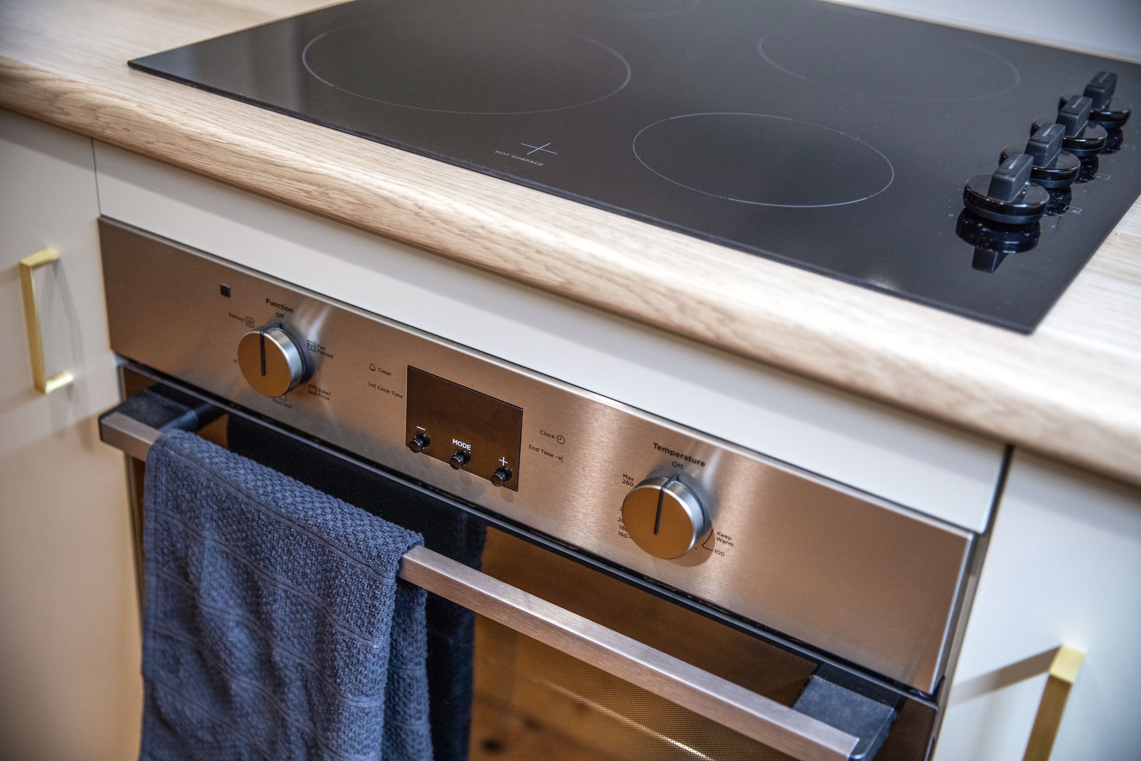 Una cocina con horno y placa de cocina integrados, que incluye perillas de control y una pantalla digital.