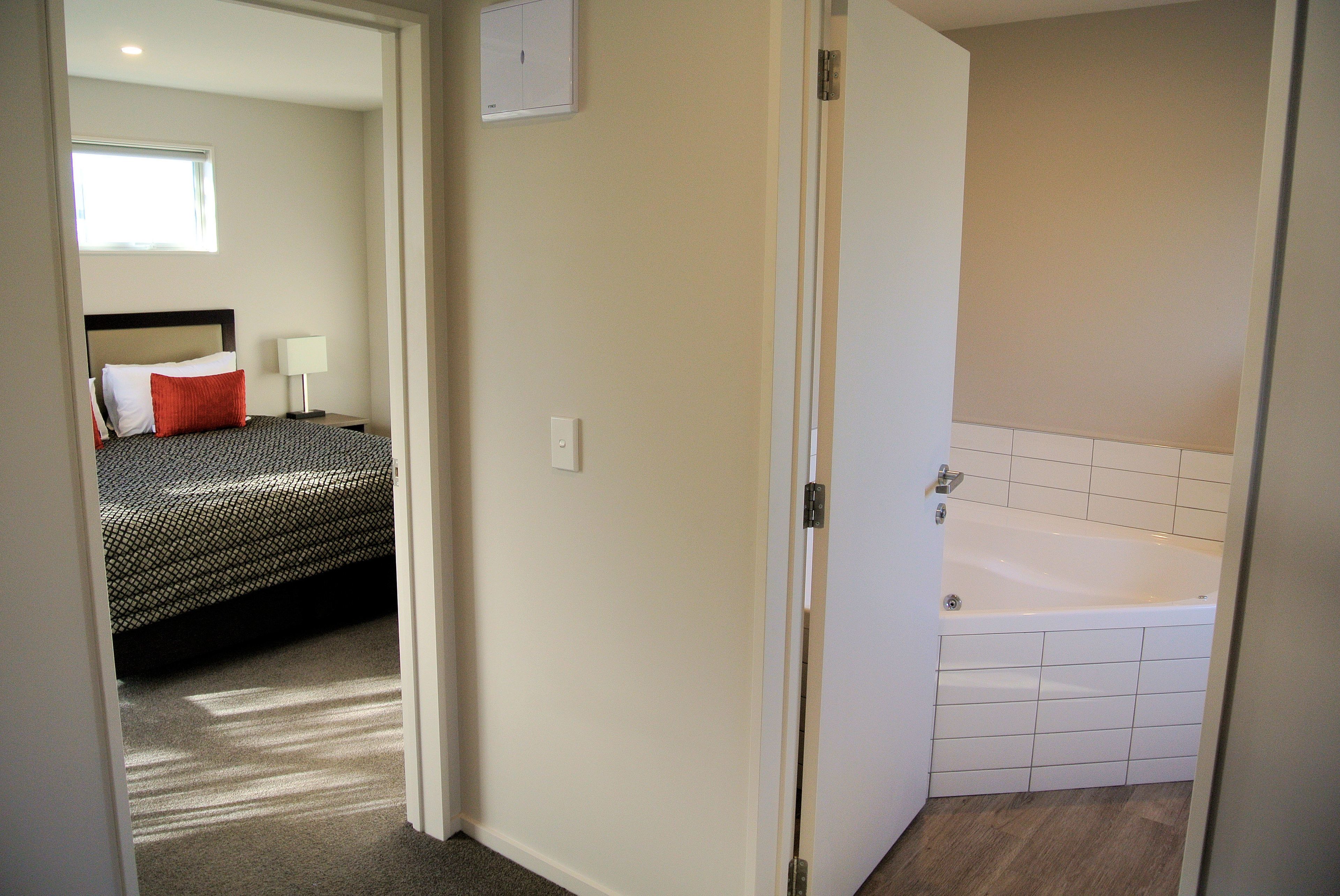 A bedroom with a bed, a nightstand, and a window.