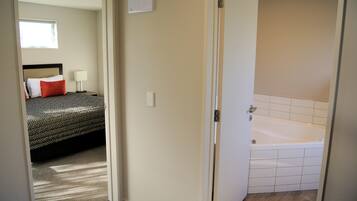 A bedroom with a bed, a nightstand, and a window.
