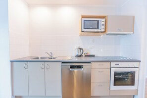 Uma cozinha moderna com lava-louças embutida, micro-ondas e forno.