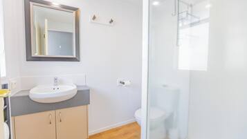 Uma casa de banho moderna com lavatório, espelho e sanita.