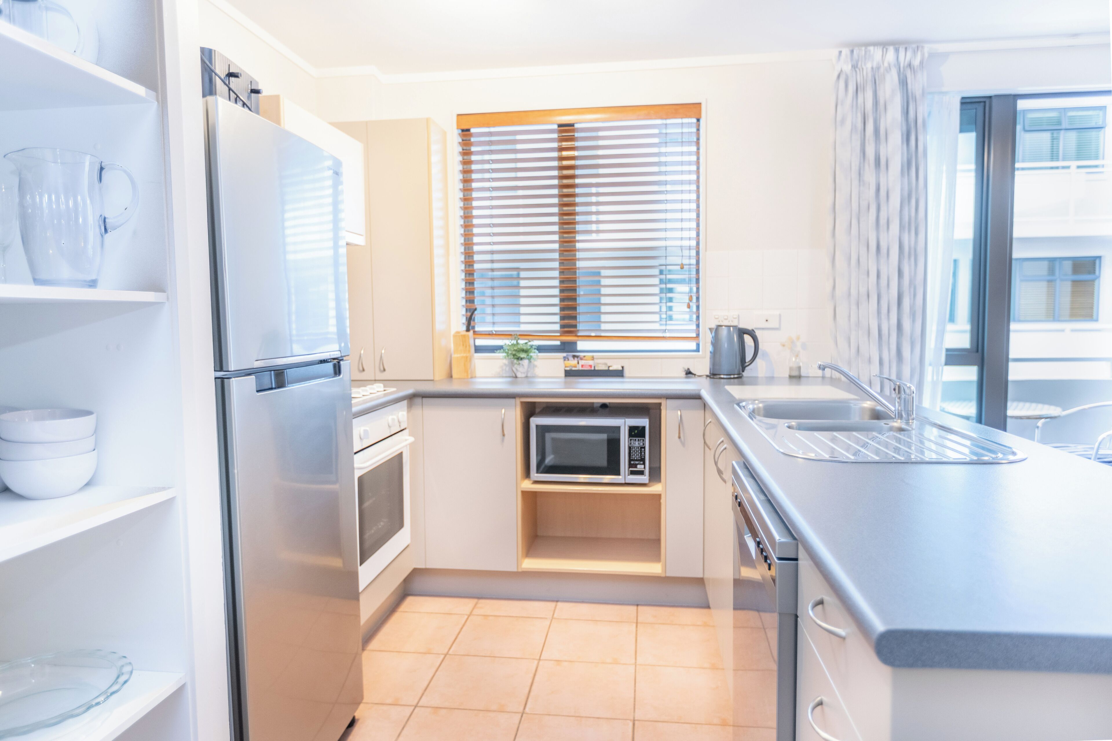 A modern kitchen with a refrigerator, oven, microwave, and sink.