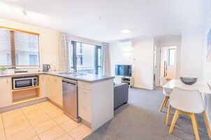 Una cocina moderna con lavavajillas, microondas y un ventanal amplio.