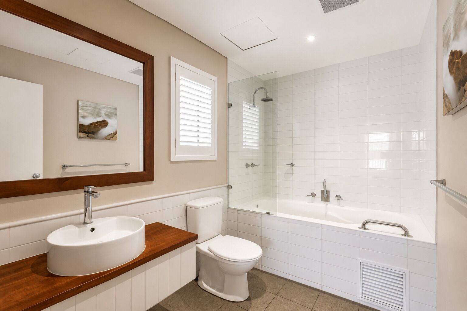 Un baño moderno con lavamanos, inodoro y ducha.