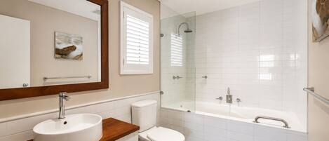 A modern bathroom with a sink, toilet, and shower.
