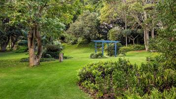 Un jardin bien entretenu, agrémenté d’un belvédère, de divers arbres et d’une pelouse verdoyante.