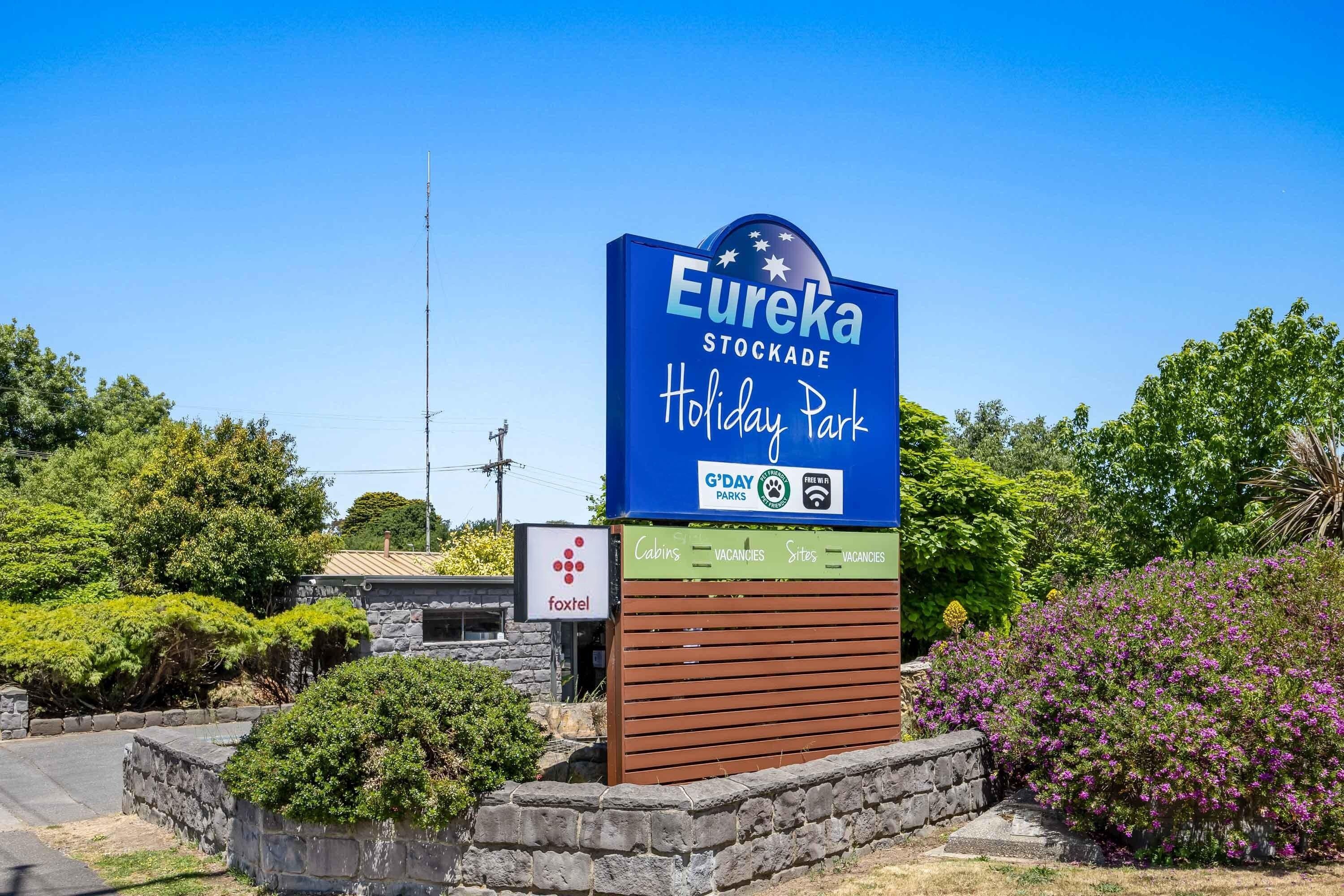 Schild für den Eureka Stockade Holiday Park mit Annehmlichkeiten wie Ferienhäusern, freien Kapazitäten und Stellplätzen.
