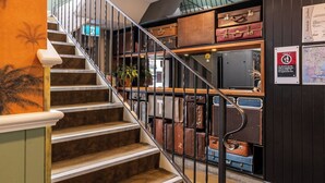A staircase with vintage suitcases arranged on shelves above. - The Lucky Hotel (Newcastle)