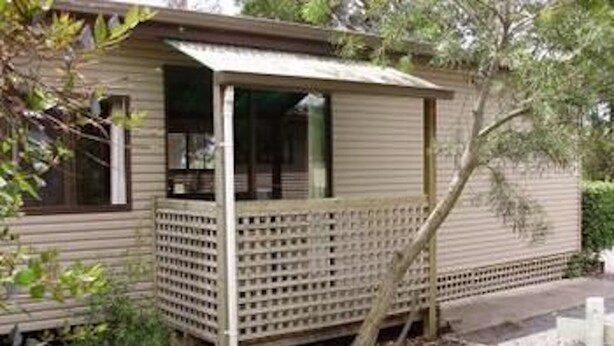 A single-story house with a porch, a small garden area, and a tree. - Launceston Holiday Park Legana (Legana)