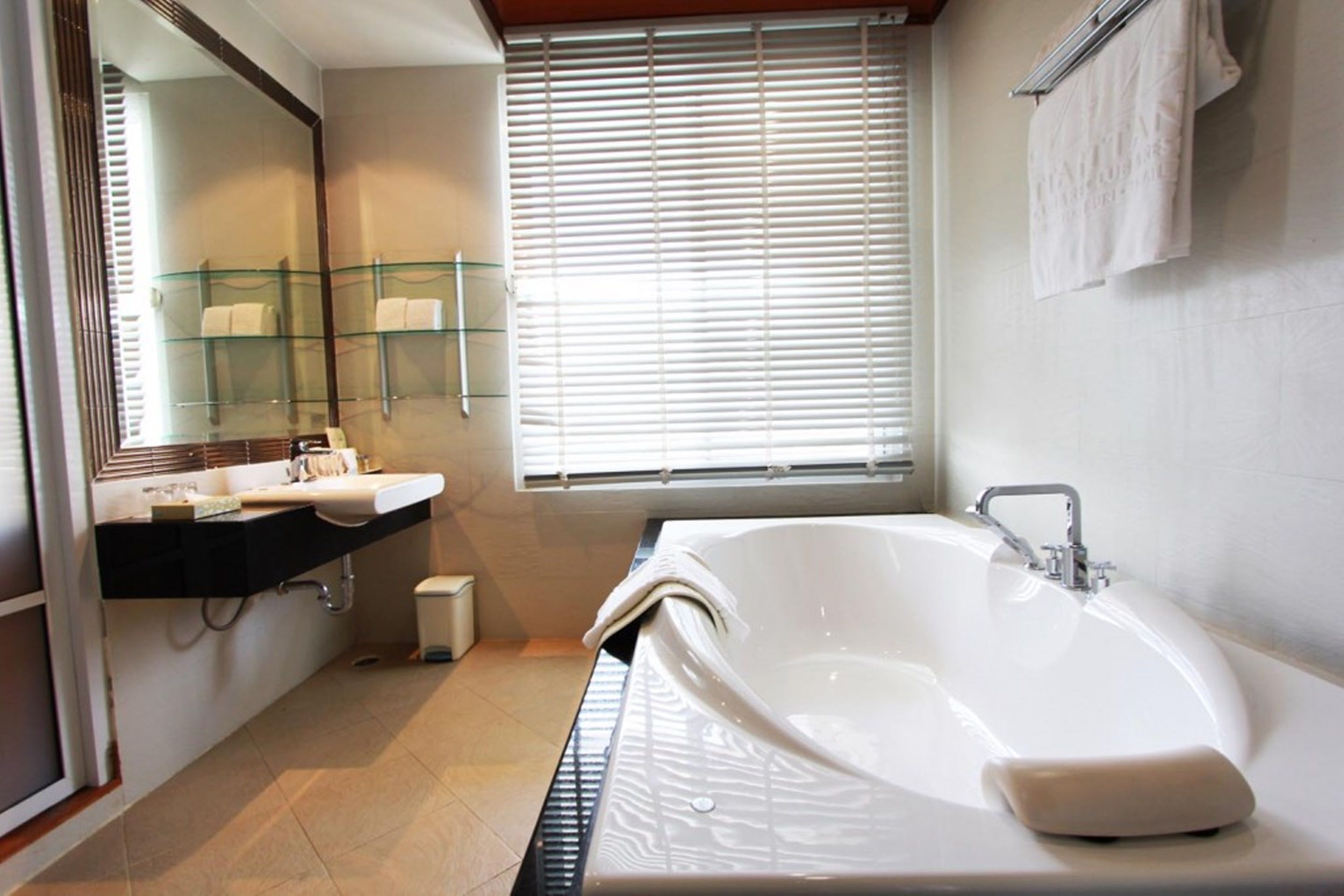 A modern bathroom with a large bathtub, a glass shower enclosure, and a vanity with a mirror.