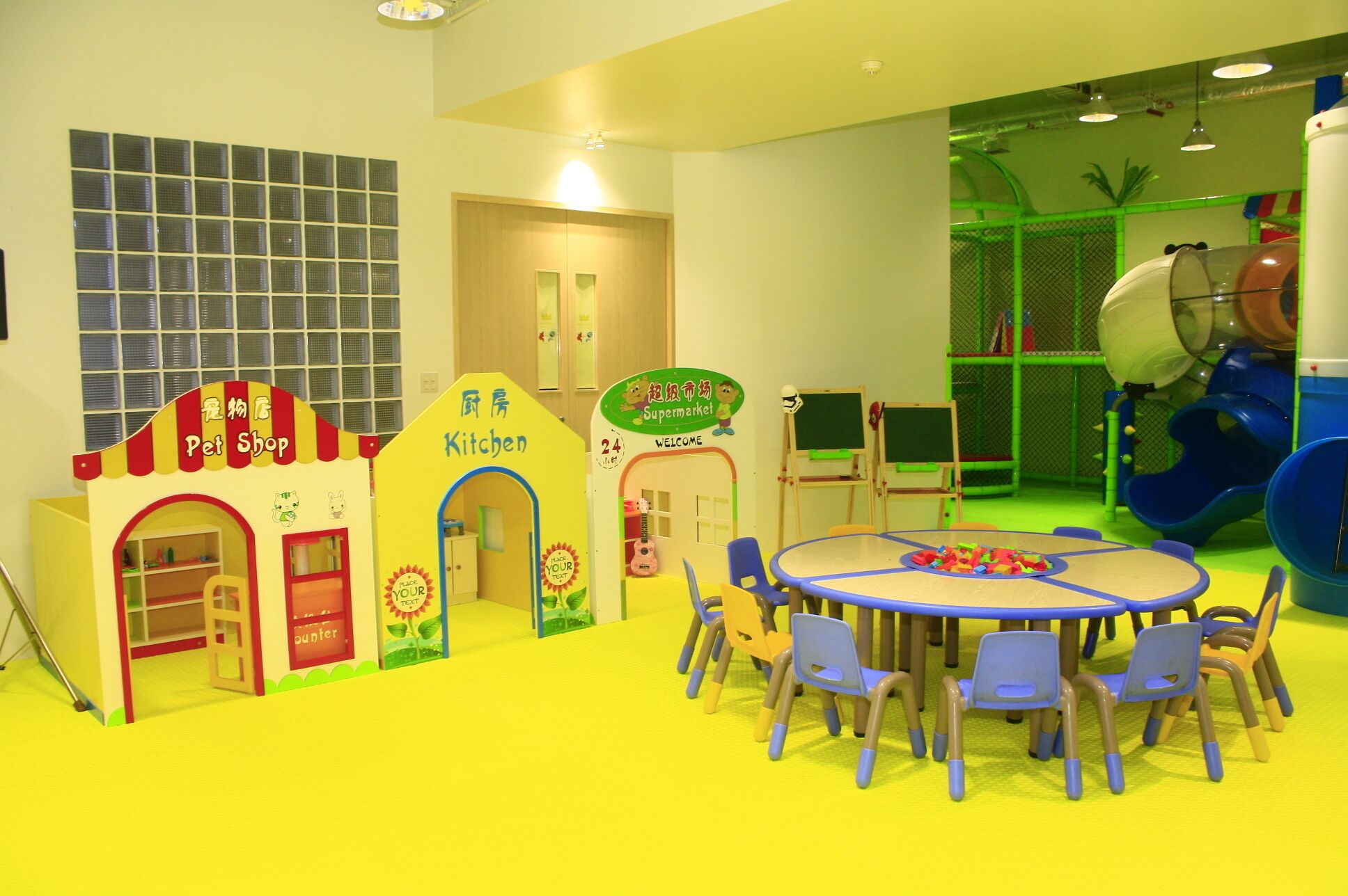 Zona de juegos infantiles con una tienda de mascotas, una cocina y un tobogán.