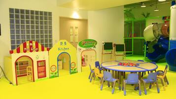 A children's play area with a pet shop, kitchen, and a slide.