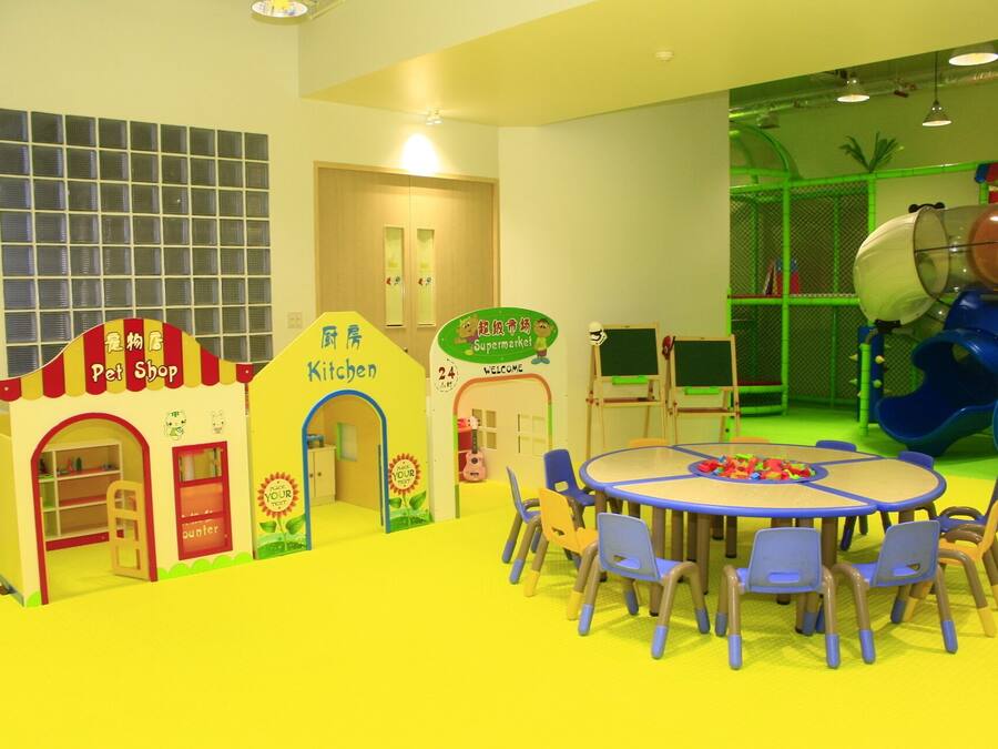 A children's play area with a pet shop, kitchen, and a slide.
