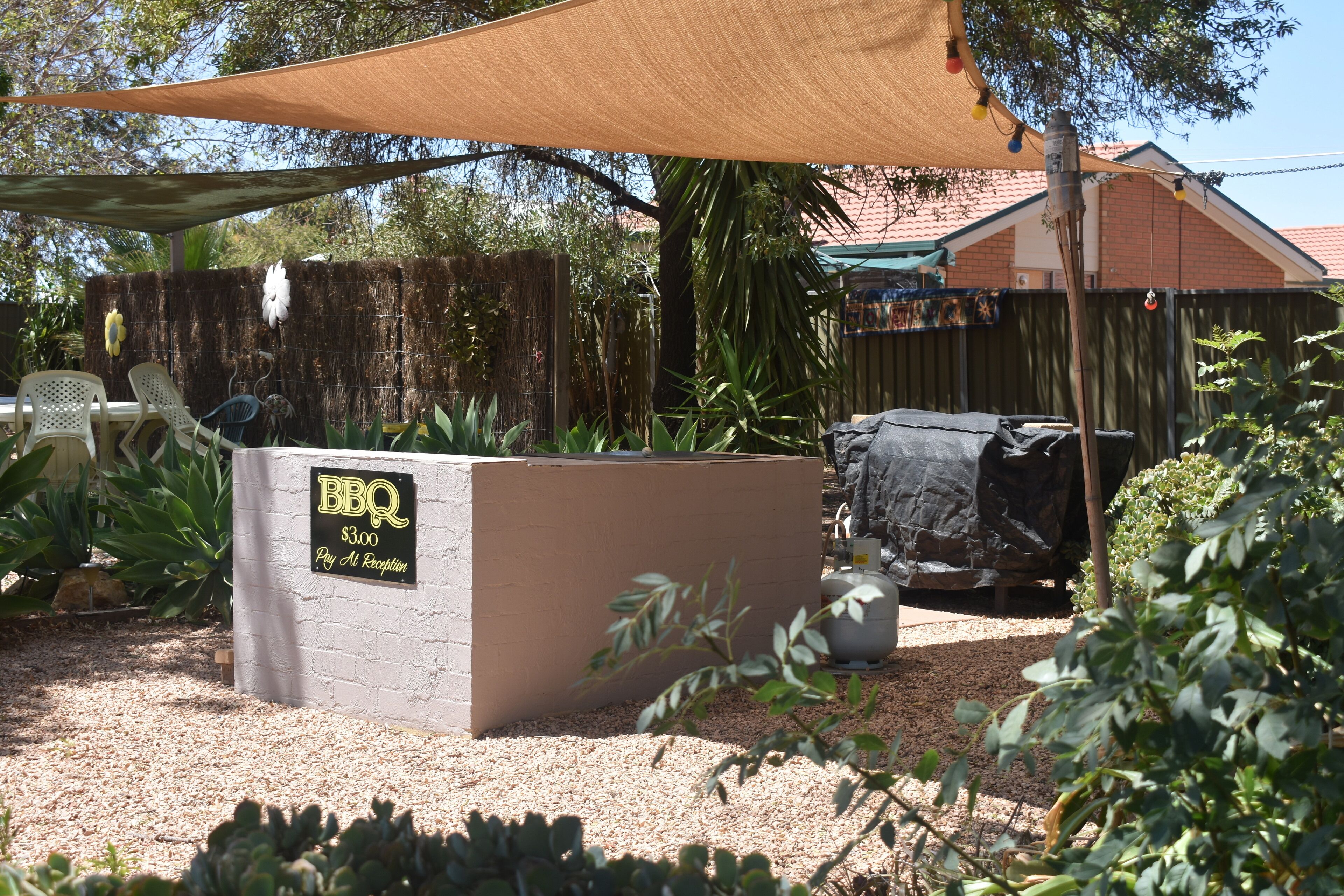 Zona de barbacoa con un cartel que indica 3,00 dólares por persona.