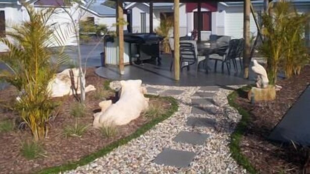 A gazebo with a thatched roof, surrounded by outdoor seating and palm trees. - Annand Mews Serviced Apartments (Harristown)
