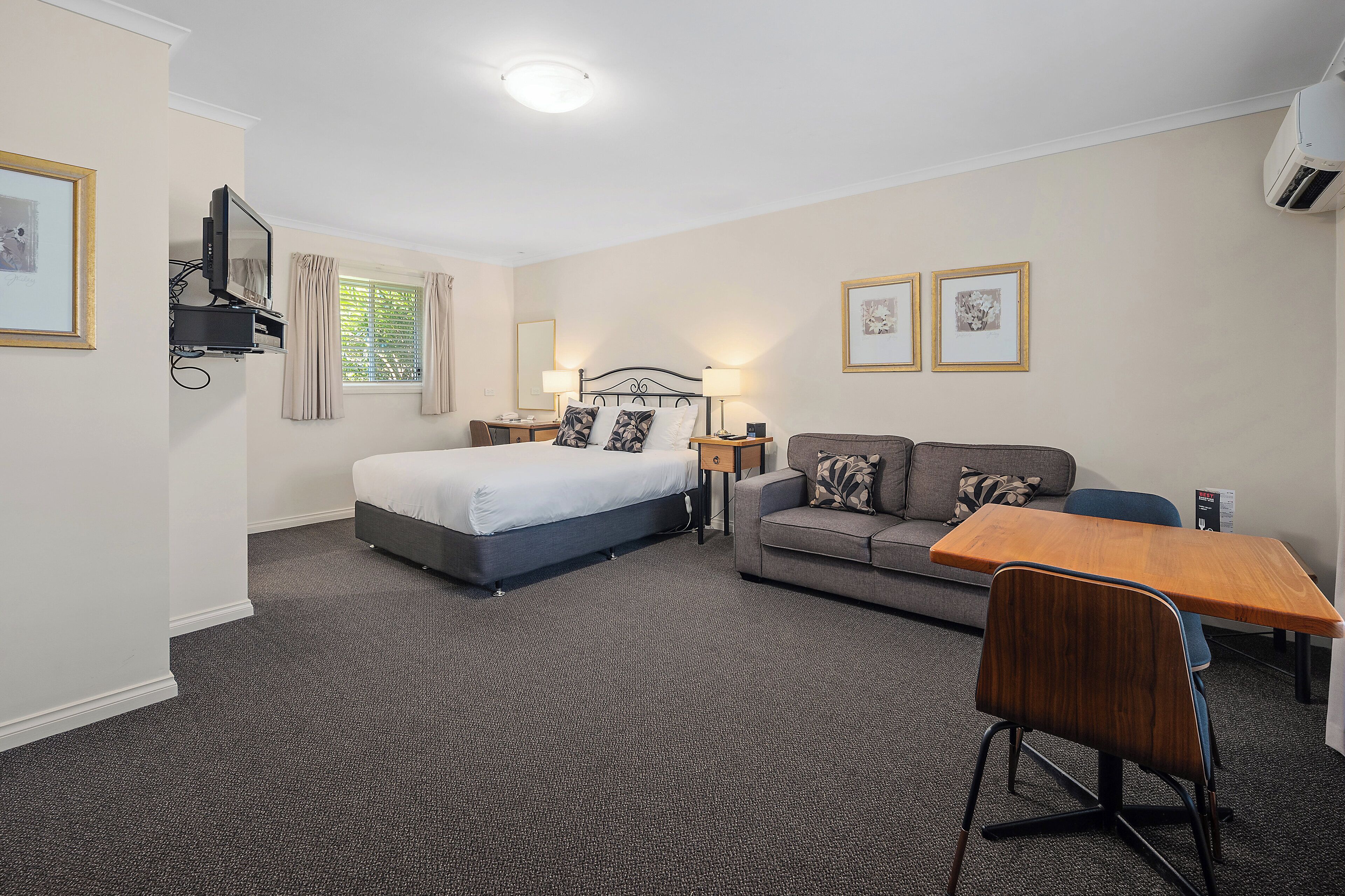 Una habitación de hotel con cama, sofá, escritorio y silla.