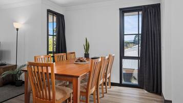 Un comedor con una mesa y sillas de madera, una planta en maceta y una lámpara.