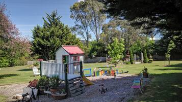Children can play and explore in this vibrant play area featuring a playhouse, slide, seesaw, and climbing structure.