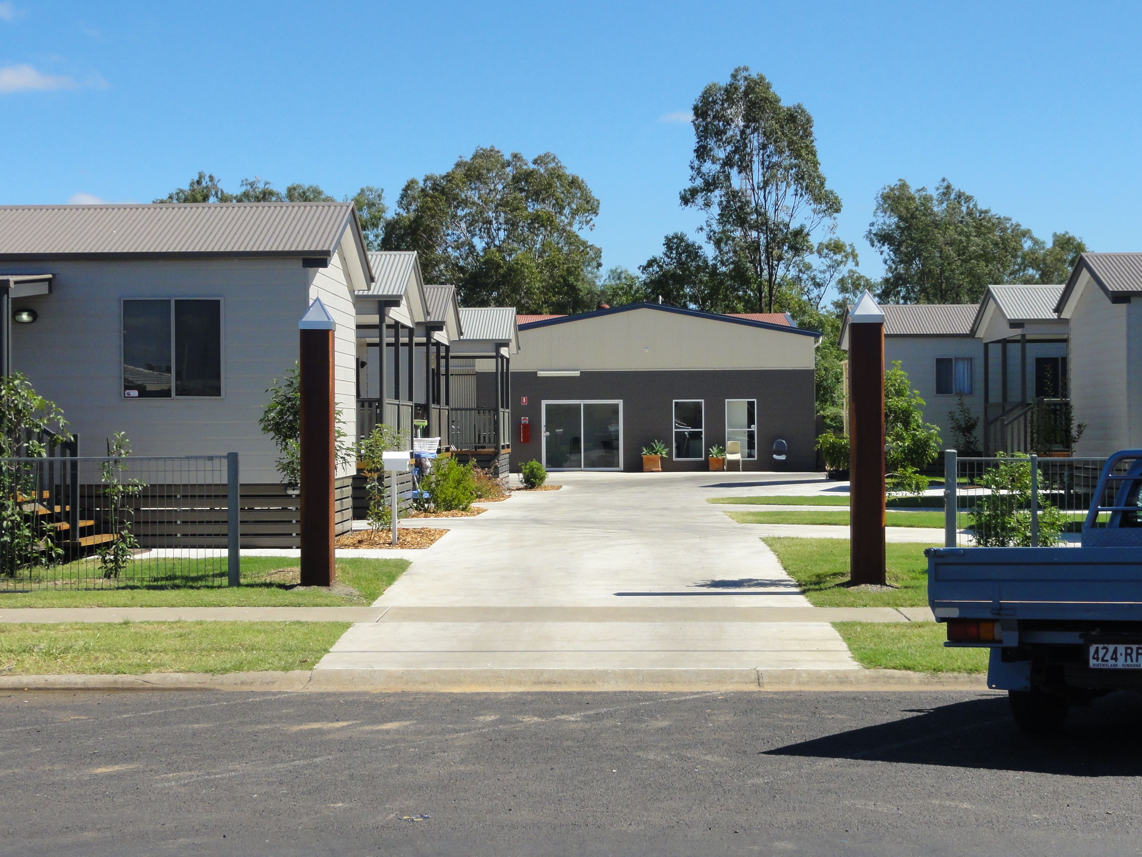 Un quartier résidentiel moderne, avec une rangée de maisons, une allée bien dégagée et un camion garé.
