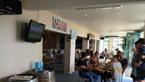 Um restaurante com ambiente descontraído, com mesas e cadeiras dispostas para os clientes.