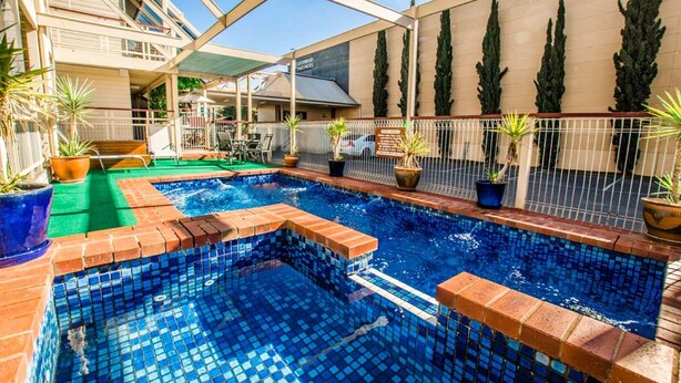 A swimming pool with blue mosaic tiles, surrounded by potted plants and a white fence. - The River Boat Hotel - Echuca (Echuca)