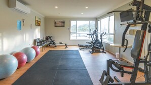 Une salle de sport équipée de matériel d’exercice, dotée d’une grande fenêtre et offrant une vue sur l’extérieur.