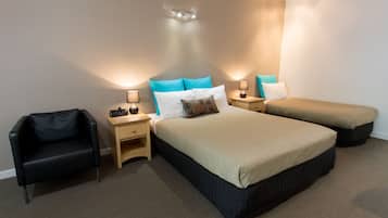 Un dormitorio con dos camas, una silla y mesitas de noche con lámparas.