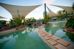 A swimming pool with stepping stones leading into the water, surrounded by shaded areas and greenery. - Tasman Holiday Parks - Moama on the Murray (Moama)